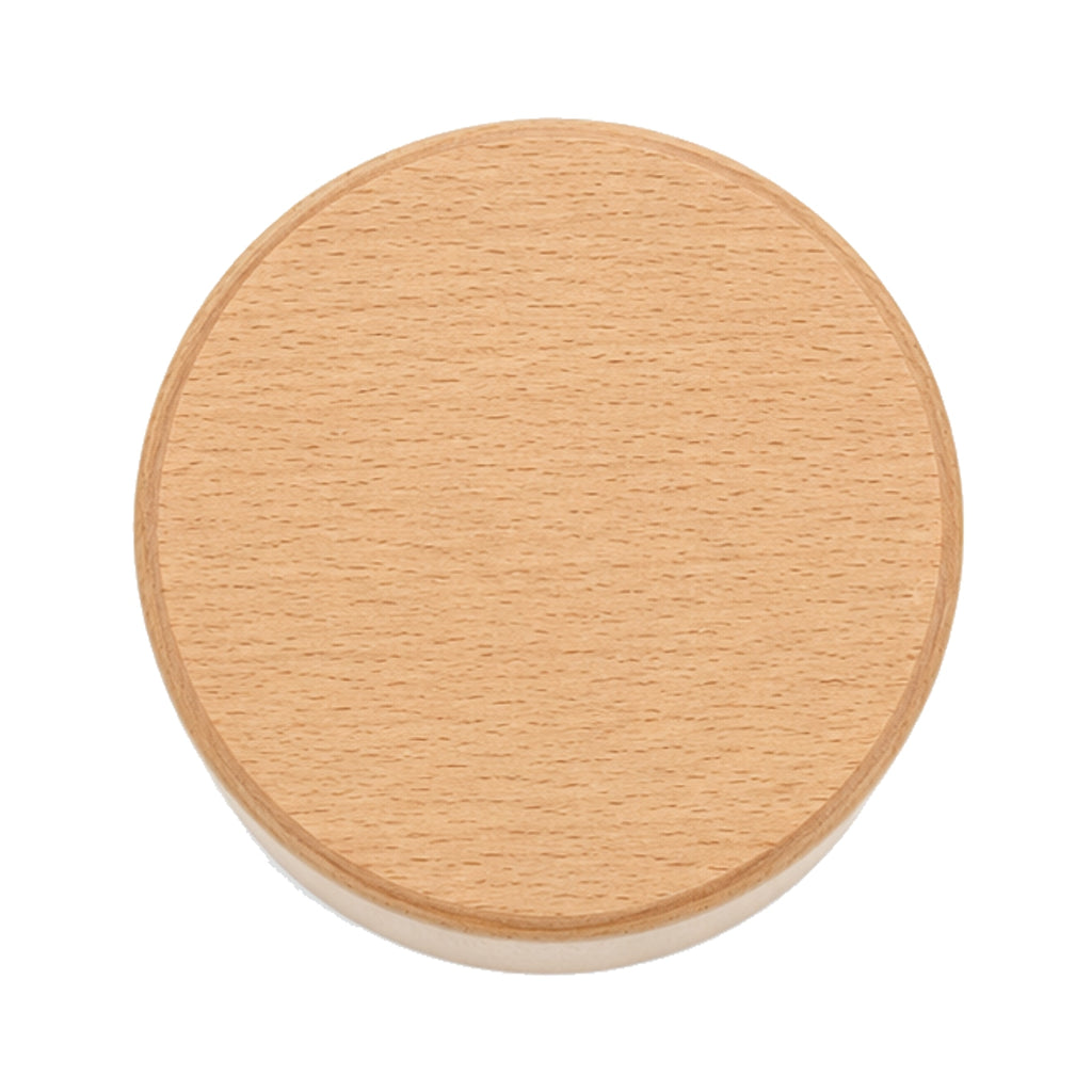 Portalápices cilíndrico ancho sobre un escritorio, color beige.
