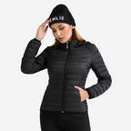 Mujer vistiendo chaqueta acolchada ultraligera ORNISHOP en entorno natural de montaña, mostrando libertad de movimiento