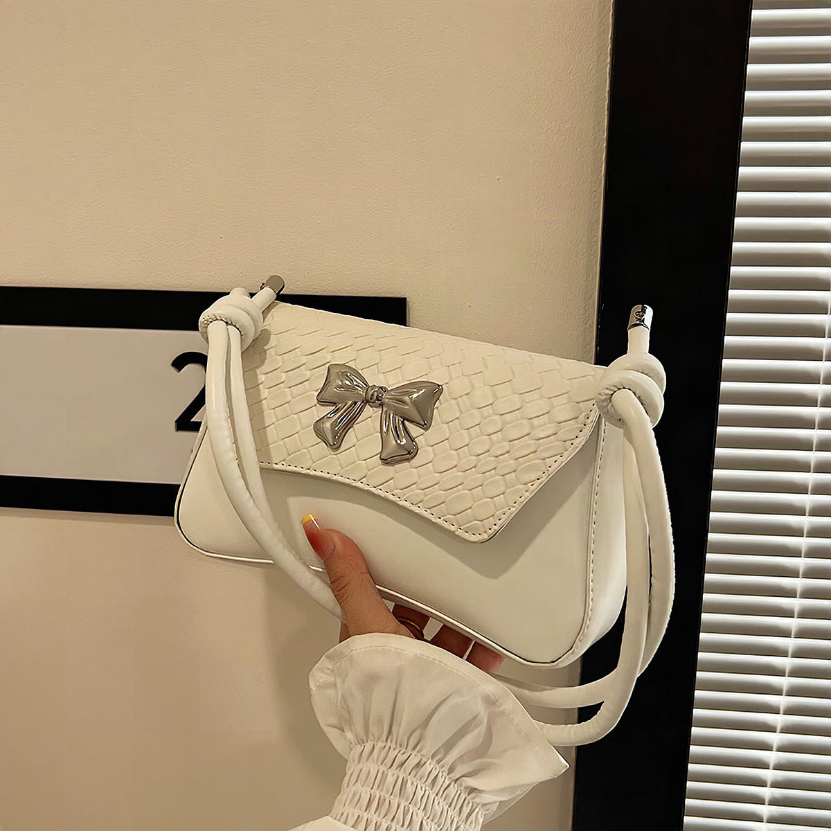 Clutch de mano con lazo decorativo