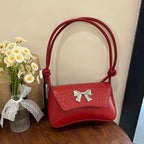 Clutch de mano con lazo decorativo