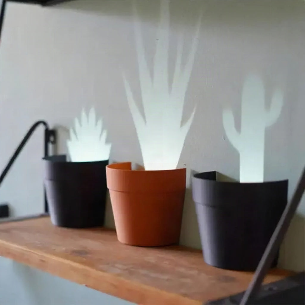 Maceta con proyección de luz y 7 siluetas de plantas para decoración de pared