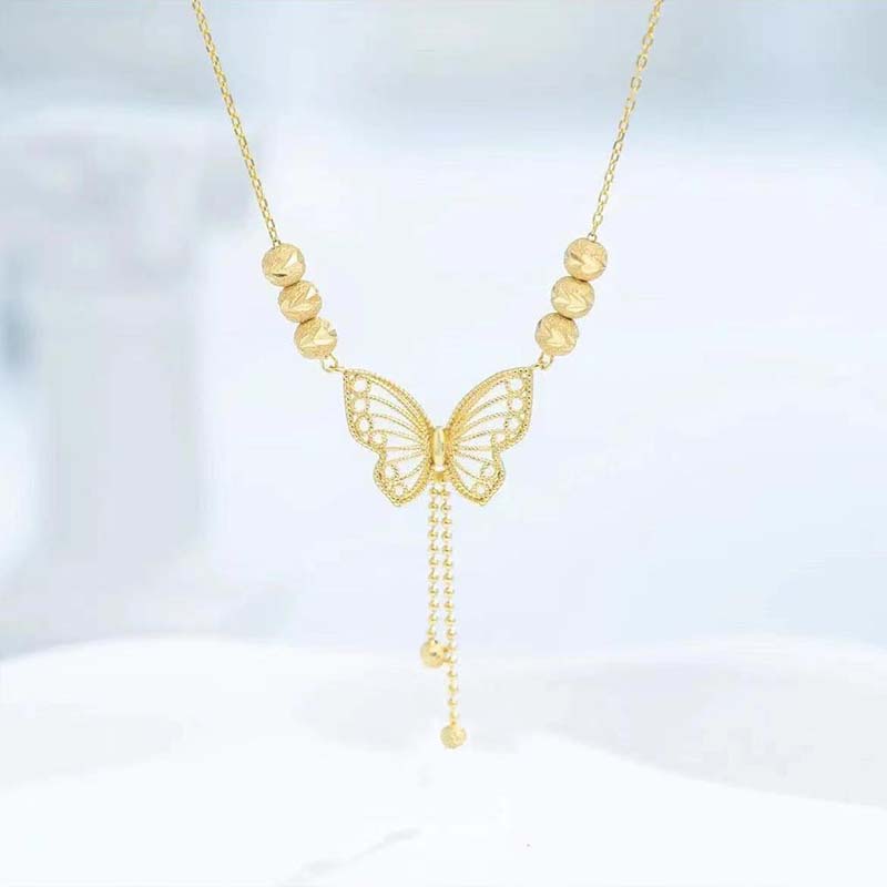 Collar con mariposa calada dorada y borlas