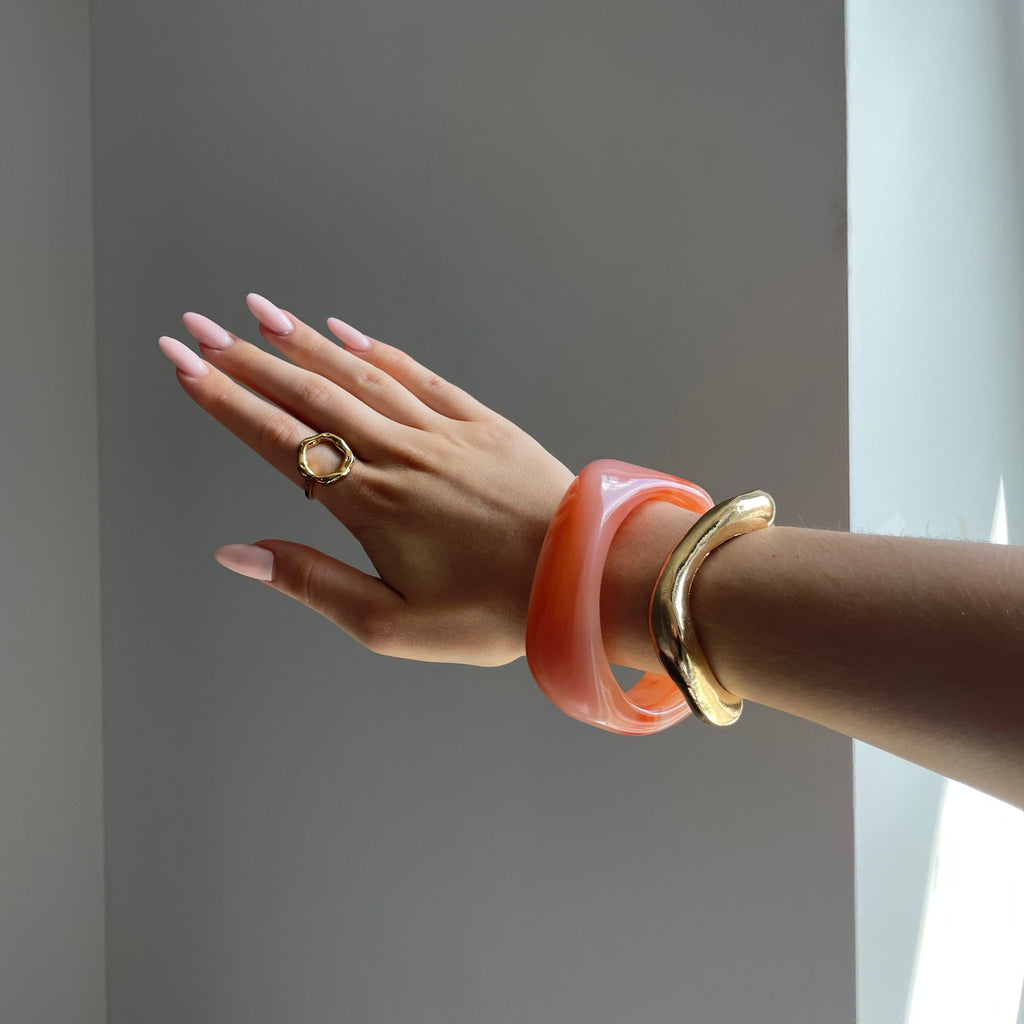 Pulsera dorada en naranja – Un acento elegante para looks modernos