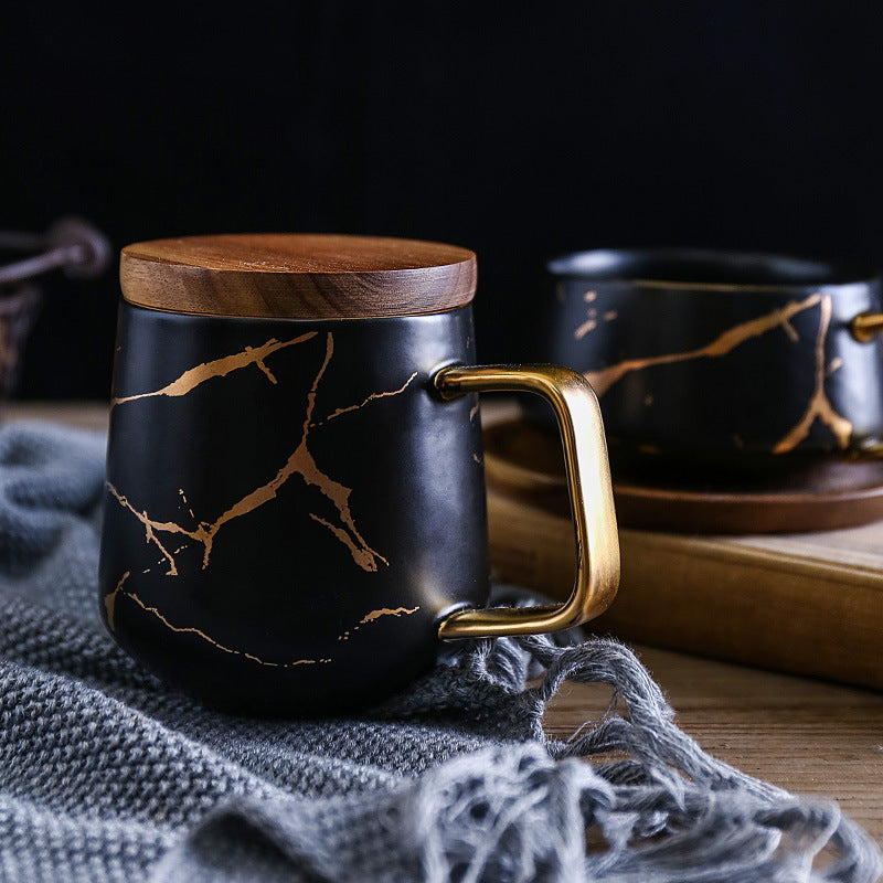 Taza de té y café de cerámica con diseño marmolado dorado y plato de madera