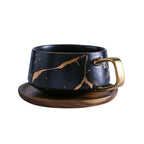 Taza de té y café de cerámica con diseño marmolado dorado y plato de madera