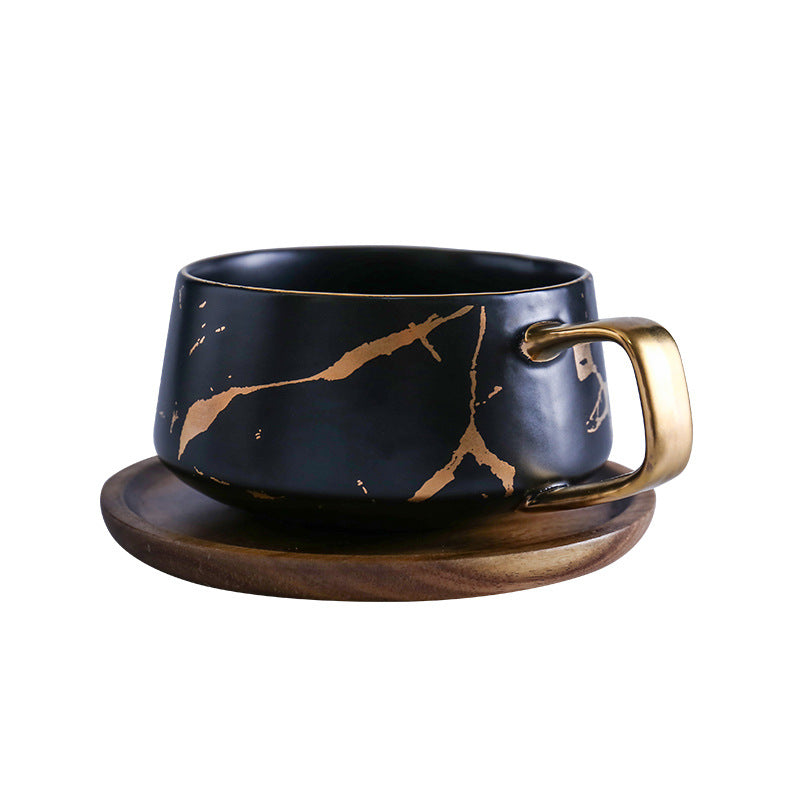 Taza de té y café de cerámica con diseño marmolado dorado y plato de madera