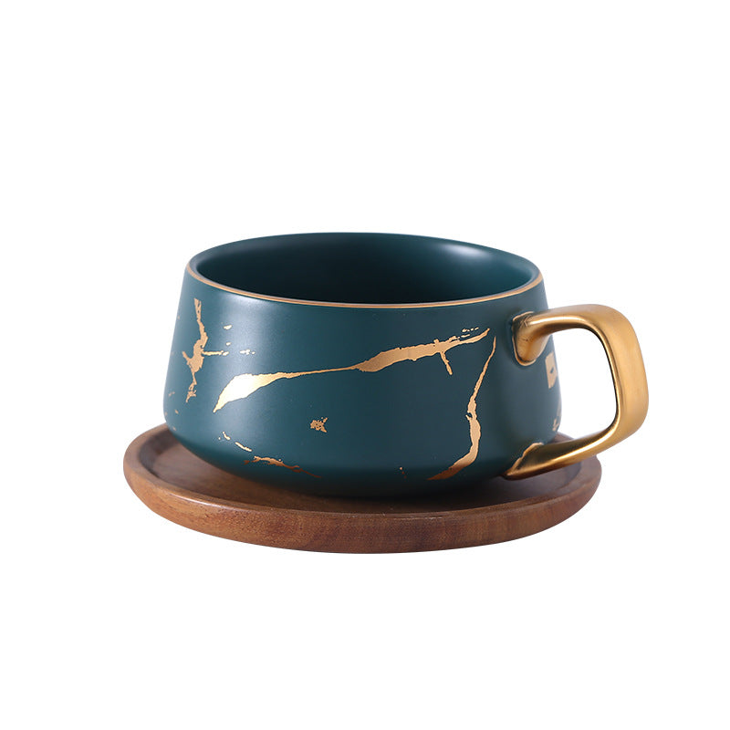 Taza de té y café de cerámica con diseño marmolado dorado y plato de madera