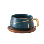Taza de té y café de cerámica con diseño marmolado dorado y plato de madera