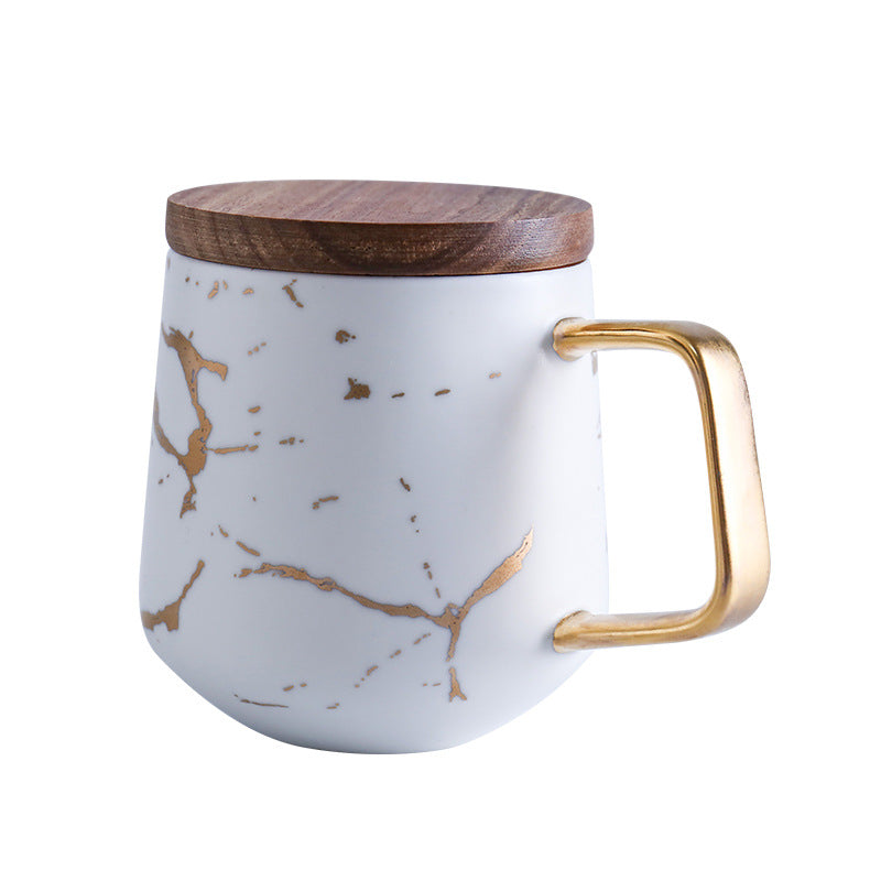 Taza de té y café de cerámica con diseño marmolado dorado y plato de madera