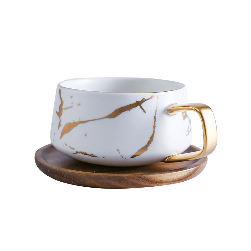 Taza de té y café de cerámica con diseño marmolado dorado y plato de madera
