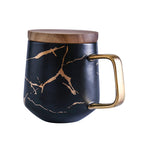 Taza de té y café de cerámica con diseño marmolado dorado y plato de madera